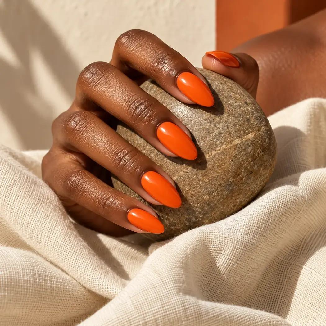 Tangerine manicure in warm light